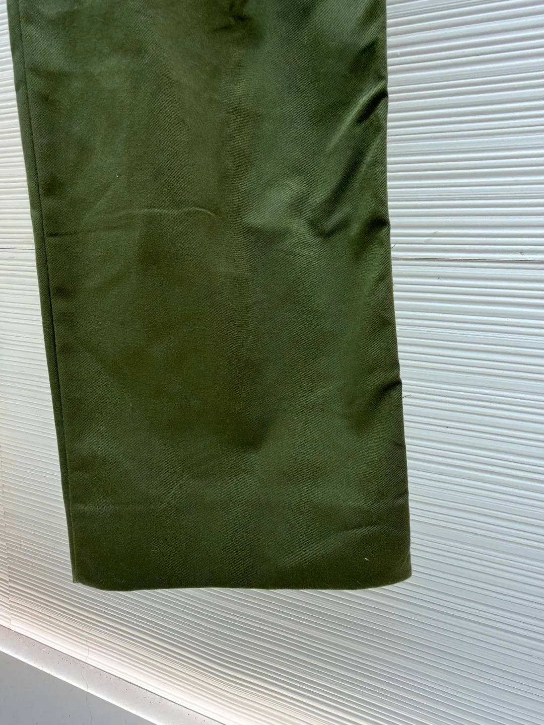 LOUIS VUITTON portrait embroidered work trousers ●Item number: 1681219-B65 ●Material: cotton twill fabric ●Technology: embroidery production ●Color: green ●Version: fitted version ●Weight: about 655 grams ●Size: 44-46-48-50 ●Description: The high cotton content ensures the fabric's excellent breathability, durability and classic workwear texture, while the twill weave gives it unique wear resistance and stiffness. The special fabric technology solves the pain points of tight and stiff traditional overalls; it provides greater freedom when moving, significantly improves wearing comfort and flexibility, and achieves a balance between function and comfort. For the embroidered portrait patch on the left, the portrait is digitally processed and converted into a line drawing blueprint that can be embroidered. A high-precision computer embroidery machine is used to perform multi-layer embroidery, and the outline, light and shade and texture details of the portrait are created by interweaving and superimposing embroidery threads of different colors. Tens of thousands of stitches and fine color transitions ensure clear lines and no unnecessary threads, making the portrait lifelike and three-dimensional. The design of the trousers combines retro workwear genes with modern deconstruction. The core lies in the neat pleat processing, which not only deconstructs the flat silhouette of the front, increases the three-dimensional sense and design level, but also visually optimizes the leg lines. Multiple flap pockets are classic workwear functional elements and the overall tough style. The overall wiring is straight and delicate, the fabric is comfortable and soft, and the color is consistent without color difference. It can be matched with the same style to create a fashionable look and control various occasions. Customized accessories, complete with three standards, same style for men and women!